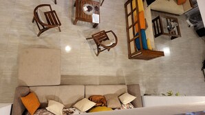 Un salon moderne comprenant un canapé, plusieurs fauteuils, une table basse et une variété de coussins.