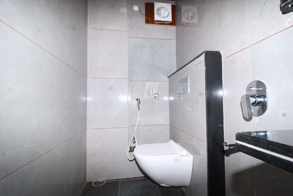 Une petite salle de bain moderne avec des toilettes blanches, une douche et un lavabo noir.