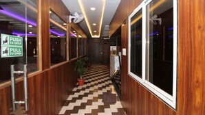 Un pasillo con paneles de madera, suelo de cuadros y una recepción.