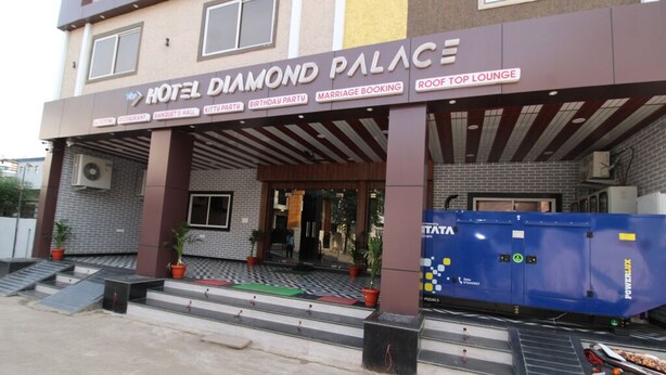 Entrada de un hotel con un cartel que dice "HOTEL DIAMOND PALACE" y servicios indicados abajo, incluyendo un restaurante, salón de banquetes y bar en la azotea.
