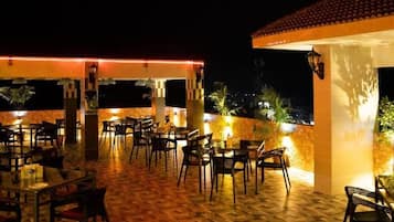 An outdoor seating area at Rooftop Restaurant with tables and chairs arranged on a patterned floor.