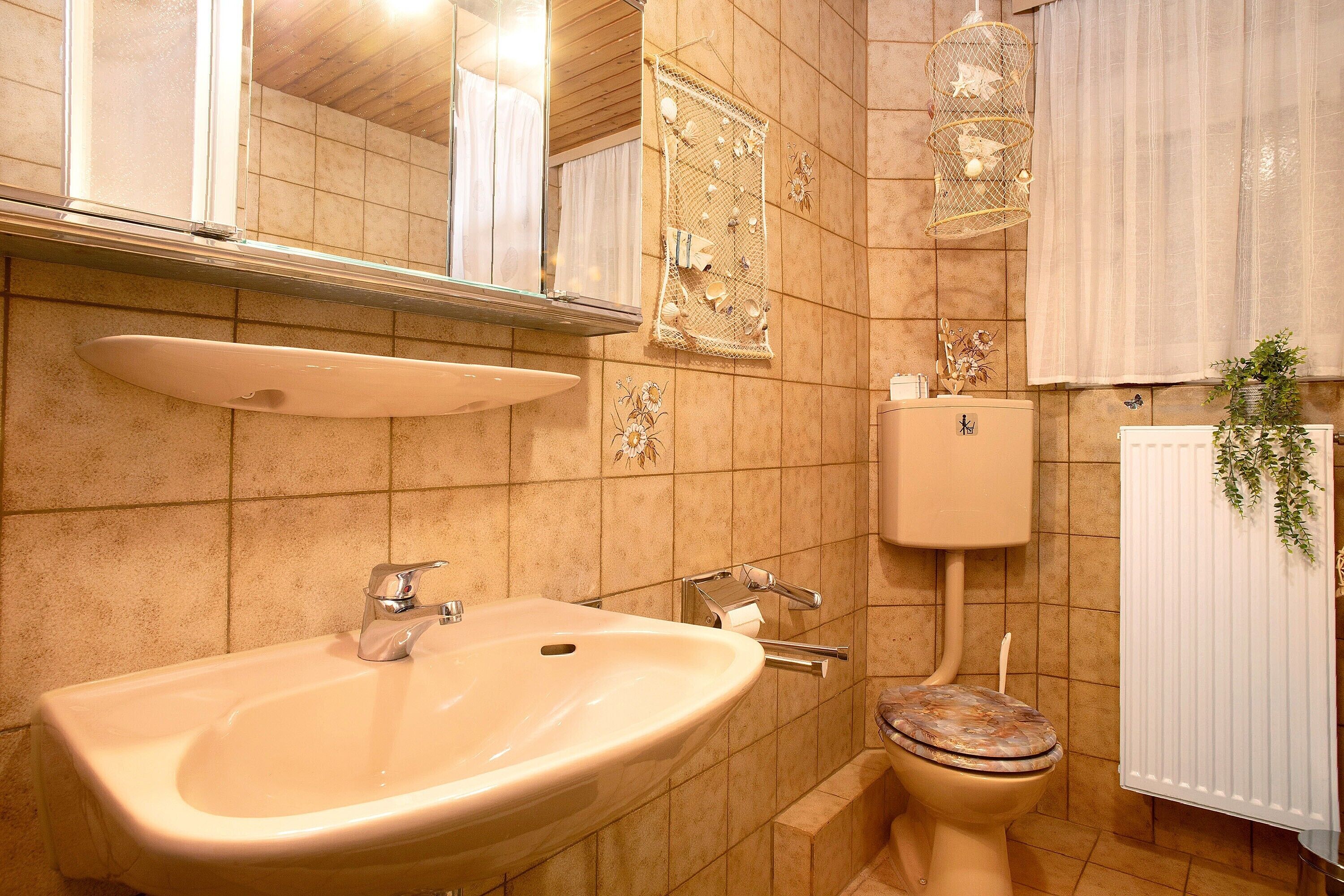 Une salle de bain avec un lavabo, des toilettes et un miroir.