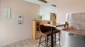 A kitchen with a wooden cabinet, a coffee machine, and a dishwasher. - Apartment 'Lux' with Private Garden, Balcony and Wi-Fi (Plettenberg)