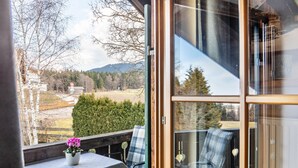 A balcony with a table, chairs, and a potted plant. - Holiday Apartment "Haus Alpenquelle Seeblick" with Mountain View, Balcony & Wi-Fi (Bad Kohlgrub)