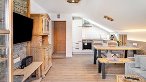 A modern kitchen with a wooden countertop, a built-in oven, and a dining area with a table and chairs. - Holiday Apartment "Haus Alpenquelle Seeblick" with Mountain View, Balcony & Wi-Fi (Bad Kohlgrub)