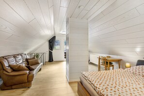 Ein Zimmer mit Bett, Sofa, Schreibtisch und Heizkörper.