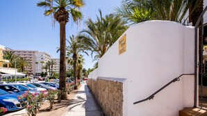 A parking area with cars, palm trees, and a building with a sign indicating it is a residential area. - Paraiso Royal I, Sunny Terrace & Heated Pool (Playa de las Américas)