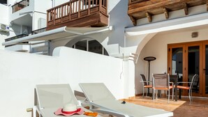 A sunlit outdoor area with two white lounge chairs, a table, and a chair. - Paraiso Royal I, Sunny Terrace & Heated Pool (Playa de las Américas)