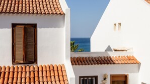 A white building with terracotta roof tiles, a wooden shuttered window, and a small door. - 395 Lovely Duplex Parque Santiago II (Playa de las Américas)