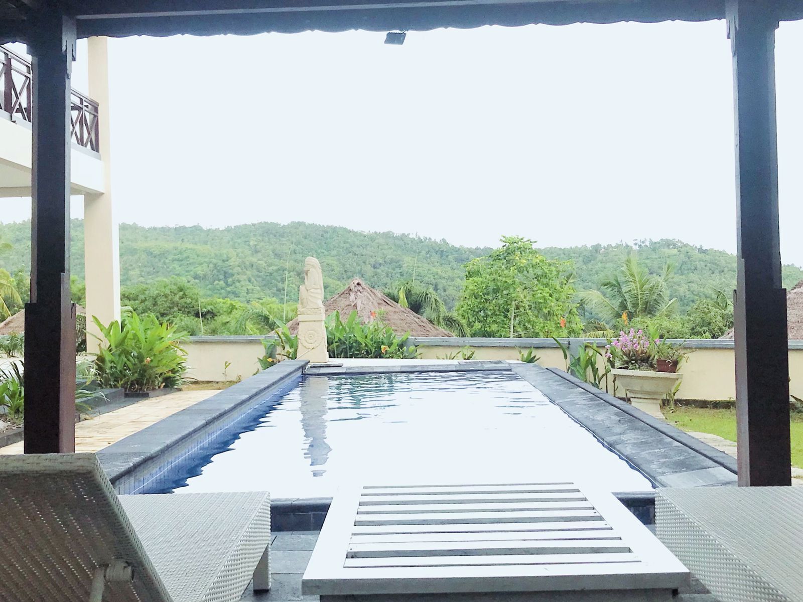 Una piscina en la azotea con vistas a un paisaje verde exuberante y una colina distante.