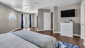 A bedroom with a bed, a dresser, a television, and a window. - Grand Casa (Las Vegas)