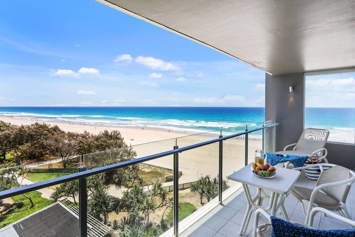 A balcony with a view of the beach and ocean.