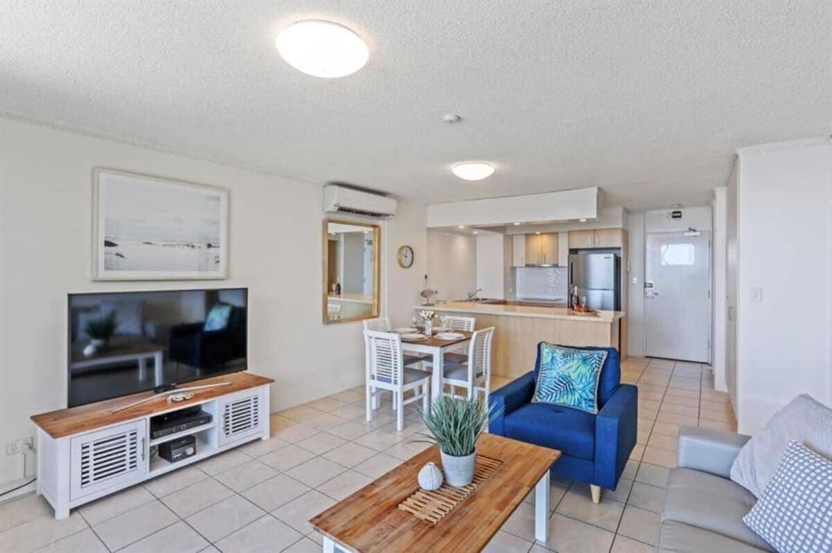 Um apartamento moderno com sala de estar, área de refeições e cozinha compacta.
