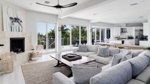 Un espacio habitable amplio con chimenea, ventilador de techo y vistas del patio exterior.