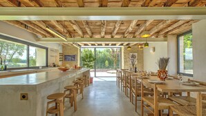 A spacious kitchen with a large island, wooden bar stools, and a dining area with a long table and chairs. - Exceptionnel farm house with pool and paddle court (Mareuil en Périgord)