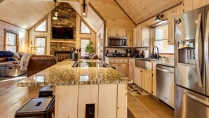 A spacious kitchen with granite countertops, stainless steel appliances, and wooden cabinetry. - Cabin w/ Hot Tub & Sauna: 5 Mi to Dtwn Blue Ridge! (Blue Ridge)