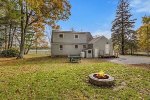 A two-story house with a fire pit in the yard. - Paws and Pines Retreat! (Ellsworth)