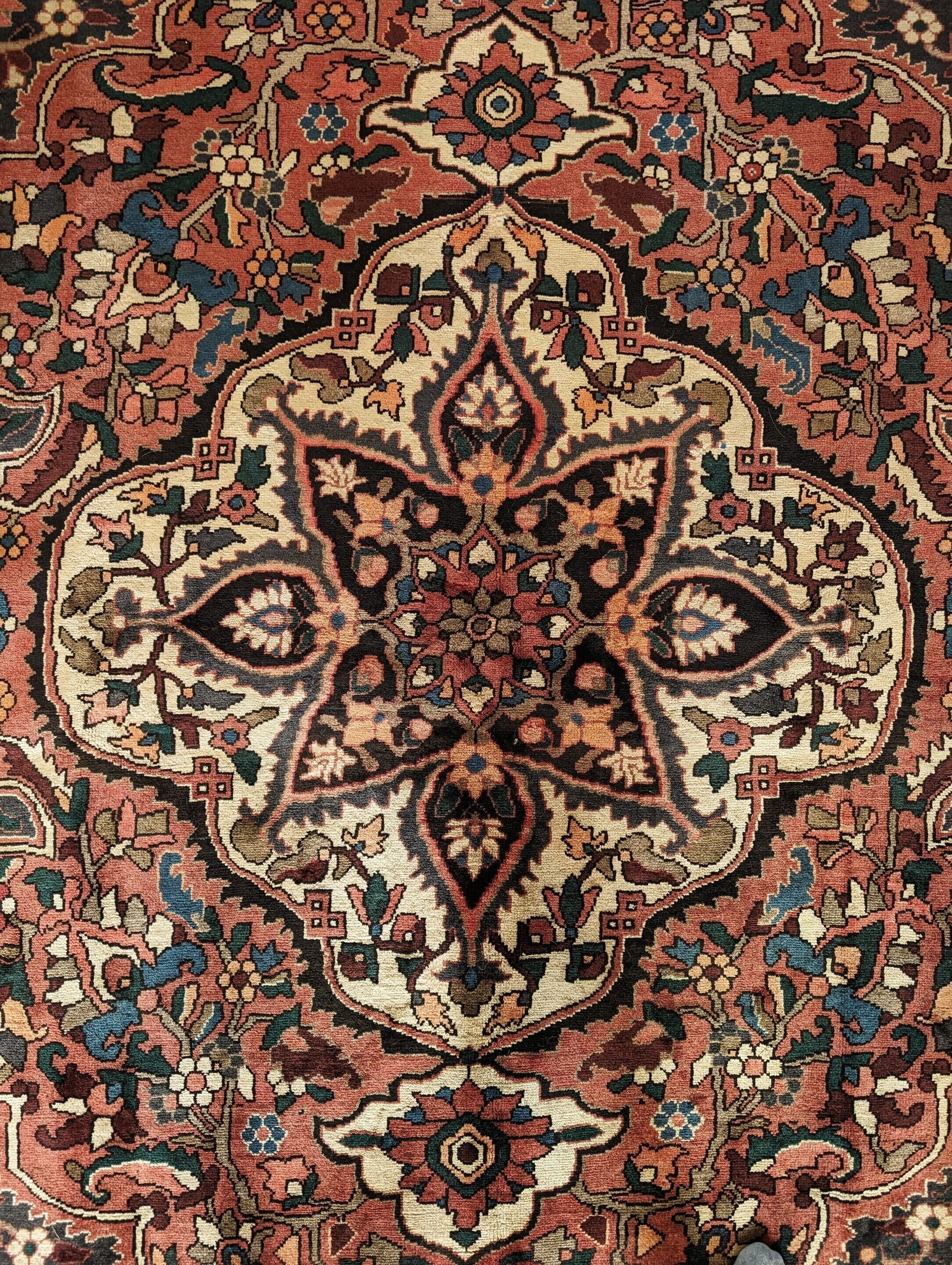 A detailed rug with a symmetrical, intricate pattern.