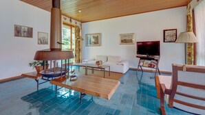 A living room with a wooden ceiling, a large fireplace, a television, and a pool table. - Villa Olivella in Sale Marasino (Sale Marasino)
