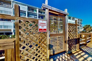 Una puerta de madera con un letrero que dice "CABANA RESIDENTS ONLY NO TRESPASSING" frente a un edificio con balcones.