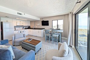 A modern living room with a sofa, ottoman, and a coffee table.