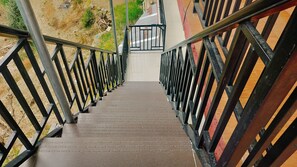 Una escalera con barandillas metálicas que lleva a una puerta.