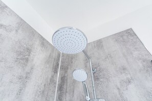 A shower with a round head and a smaller handheld showerhead, both with a perforated design, mounted on a chrome fixture. - Sleek 3-BR Apartment, Central Hartlepool (Hartlepool)