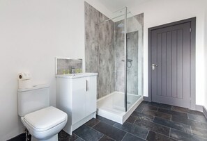 A bathroom with a toilet, a shower enclosure, and a door. - Sleek 3-BR Apartment, Central Hartlepool (Hartlepool)