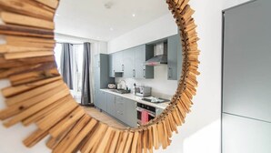 Una cocina moderna con armarios grises, un microondas y una campana extractora de acero inoxidable.