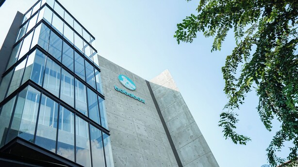 Un edificio moderno con fachada de vidrio y un logotipo en el lateral.