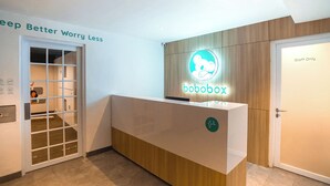 Una recepción con el logotipo de 'bobobox', una puerta que indica 'Solo Personal' y un letrero que dice 'Duerme Mejor, Preocúpate Menos'.