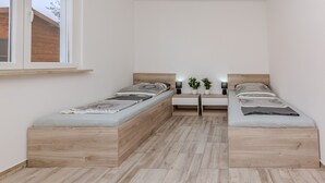 A small, modern bedroom with two wooden beds, a bedside table, a nightstand, and a window. - Holiday home Loncar (Vir)