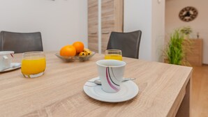 A breakfast table with orange juice, a cup, and a bowl of fruit. - Holiday home Loncar (Vir)
