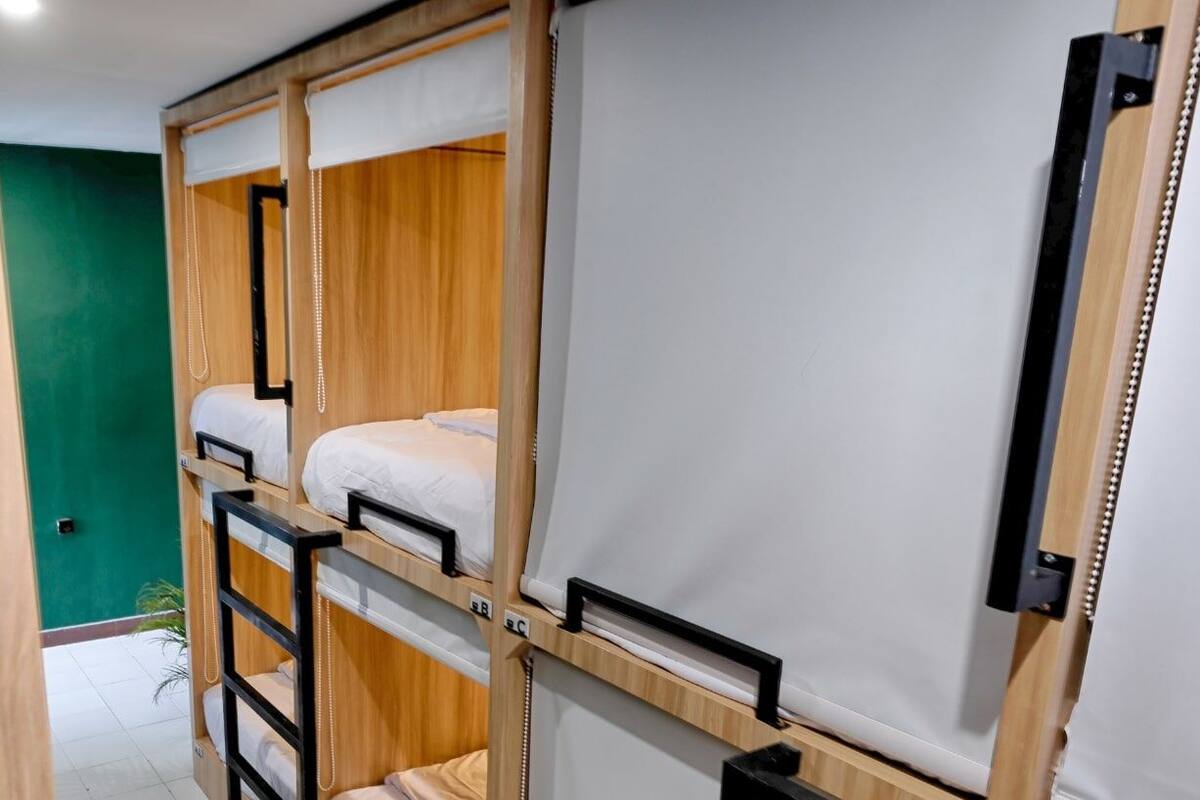 A bunk bed room with a green wall and a white door.
