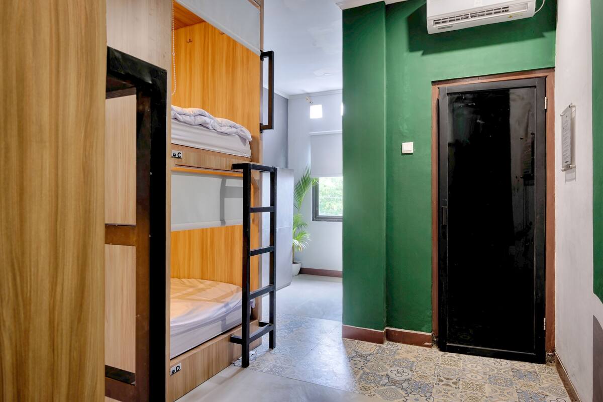 A bunk bed room with a ladder, a potted plant, and a door with a sign.