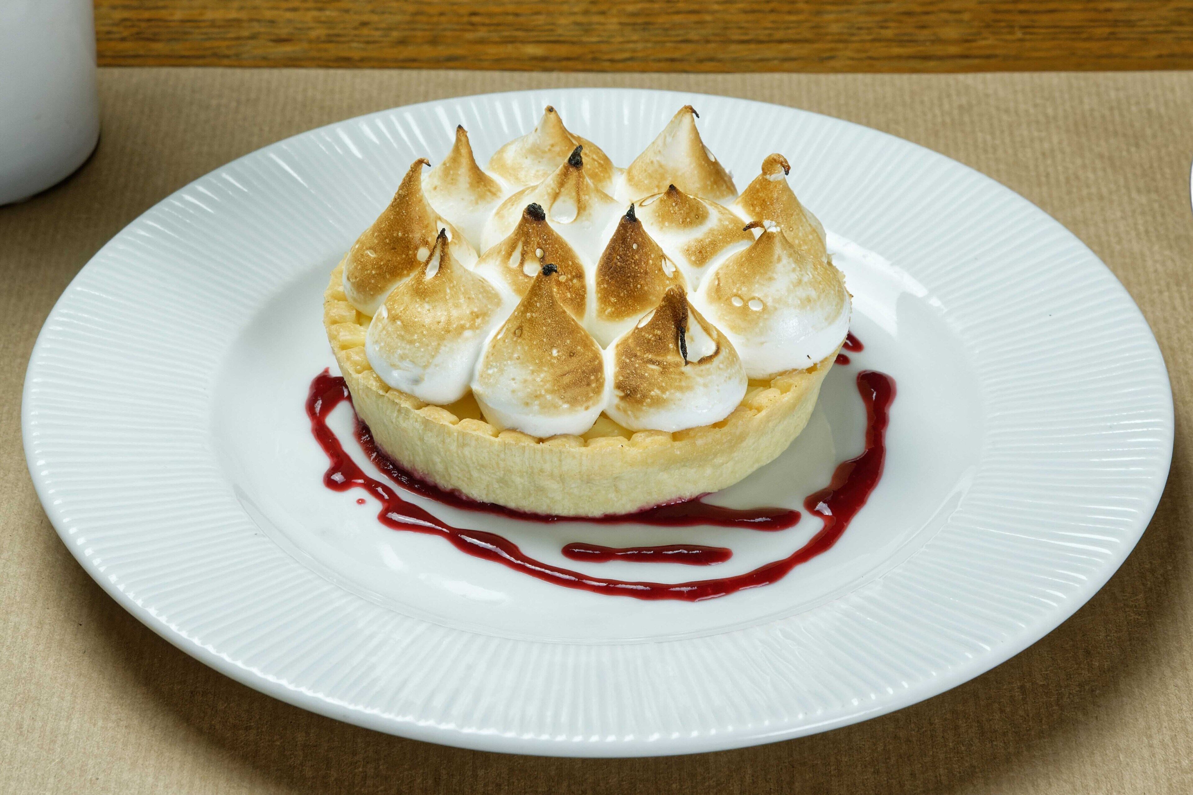 A dessert on a white plate with a red sauce.