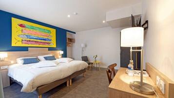 Una habitación de hotel moderna con una cama grande, mesitas de noche, un escritorio y una silla.