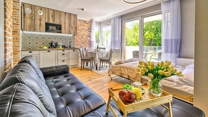 Een moderne leefruimte met een bank, een eethoek, een keuken en een bed met uitzicht.