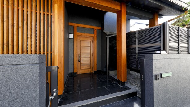 A traditional Japanese entrance with a wooden door, a tiled entrance, and a black gate. - Residence inn Makinoyado (Osaka)