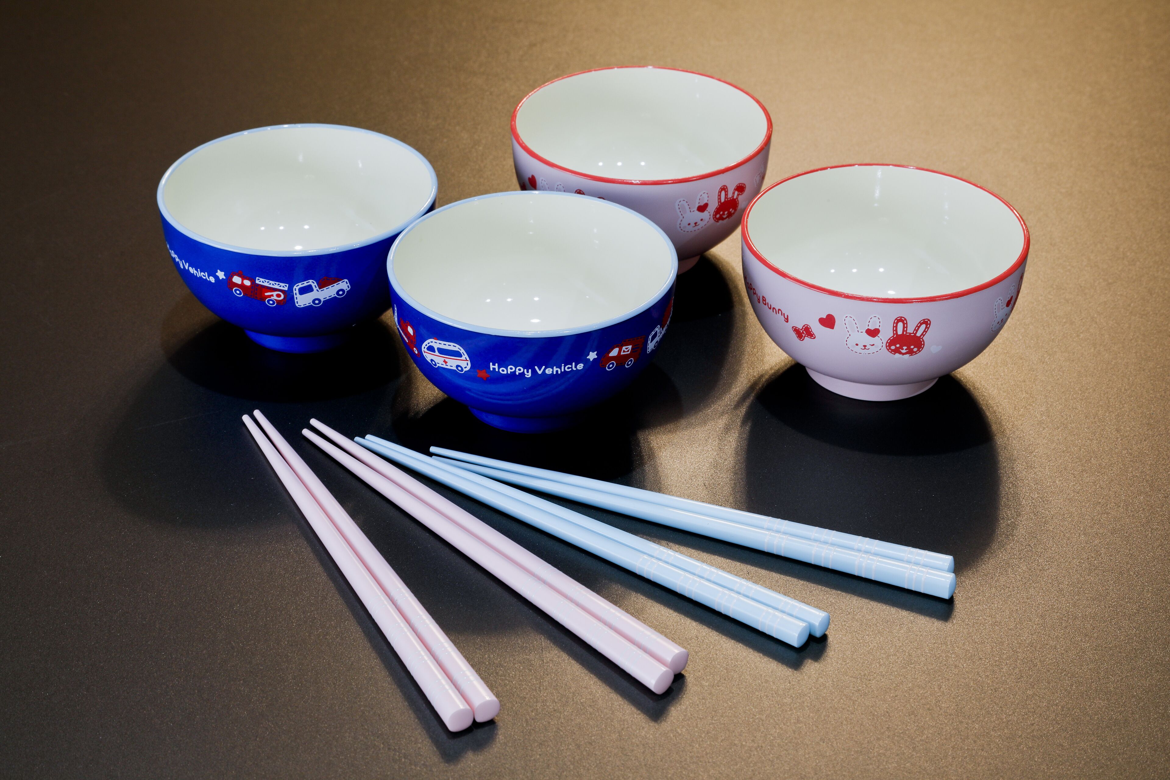 Four bowls with different designs and four pairs of chopsticks.