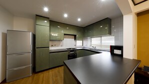 A modern kitchen with a built-in refrigerator, double oven, and a large island. - Residence inn Makinoyado (Osaka)