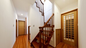 A wooden staircase in a hallway with white walls and wooden flooring. - Residence inn Makinoyado (Osaka)