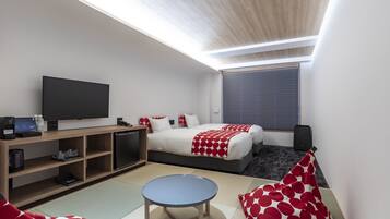 Una moderna camera d'albergo con un letto, una televisione, una scrivania e un tavolino.
