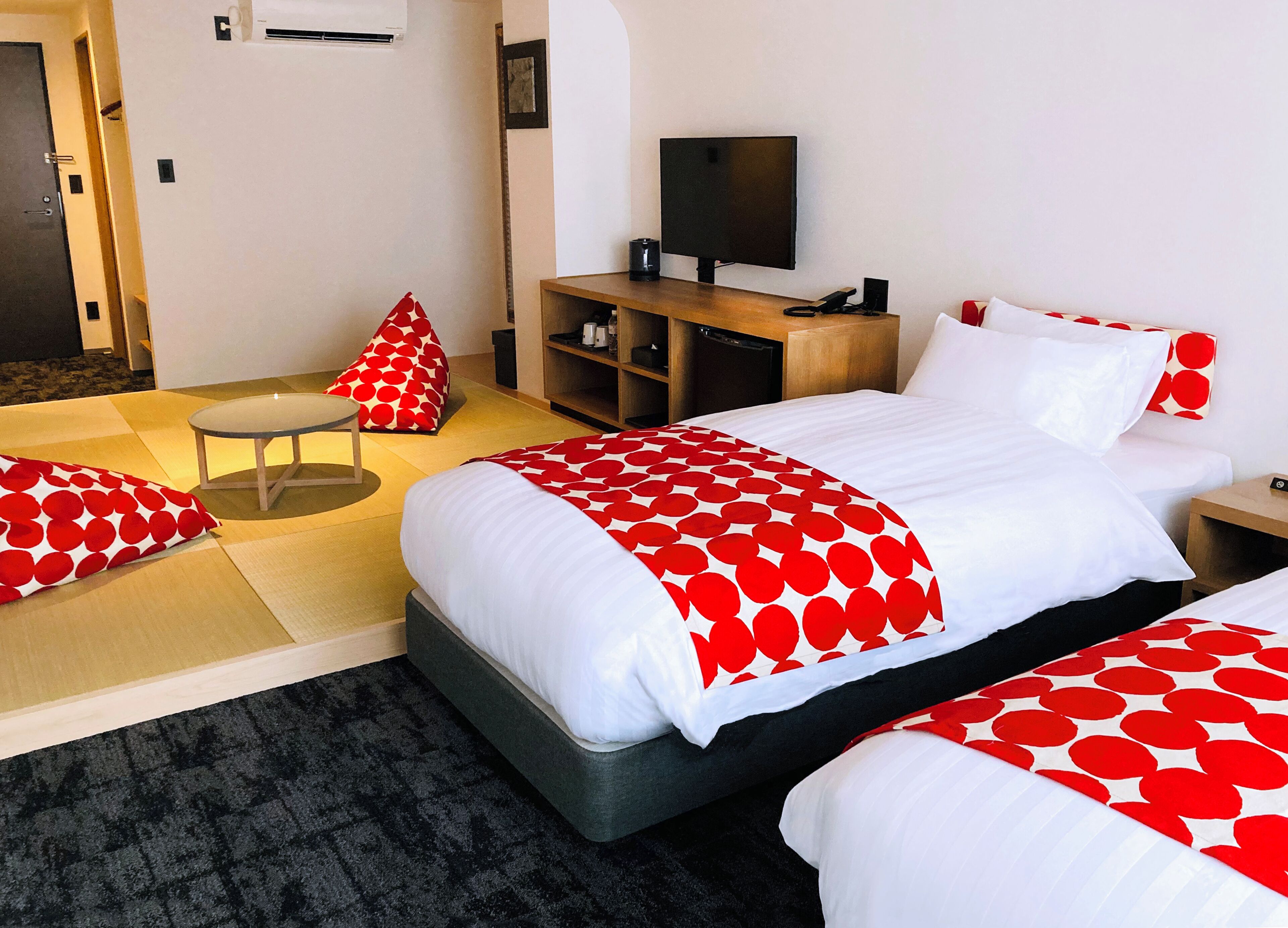 Une chambre d’hôtel avec un lit, une télévision, un bureau et une chaise.