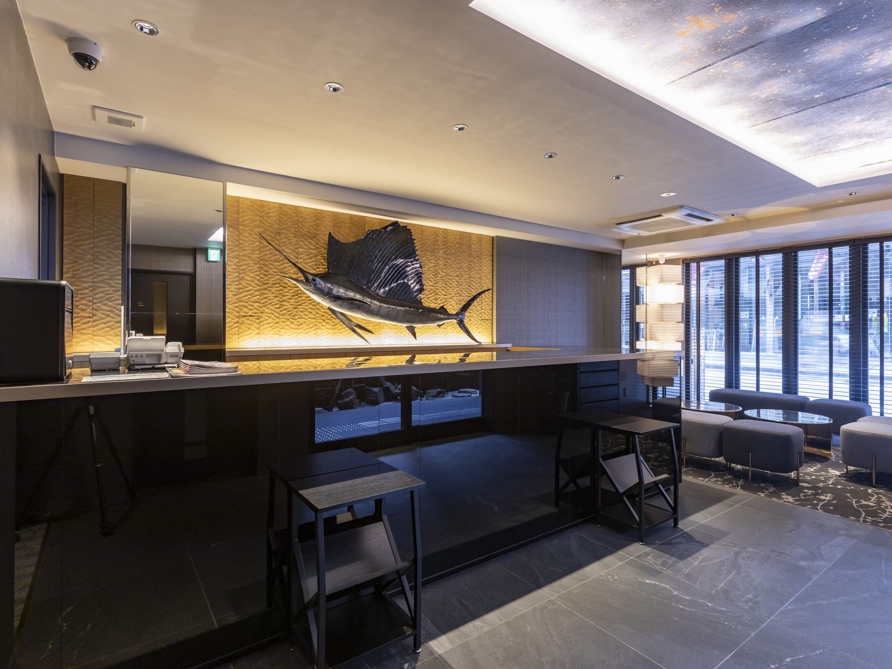 A modern reception area with a large fish mural, a counter, and seating.