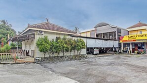 A family hotel with a tiled roof, a covered outdoor area, and a visible storefront.