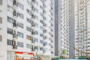 A high-rise residential building with multiple balconies and a ground-level commercial establishment. - Hotel O The Jarrdin Apartment By Putra Homestay Property (Bandung)