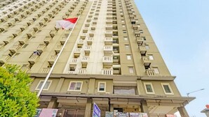 A high-rise building with multiple balconies and a flag. - Hotel O The Jarrdin Apartment By Putra Homestay Property (Bandung)