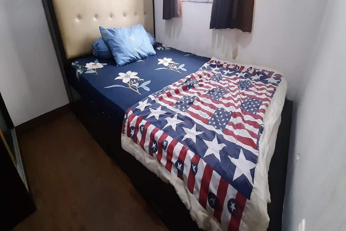 Ein Bett mit floralem Bettbezug und einer Decke mit amerikanischer Flagge.