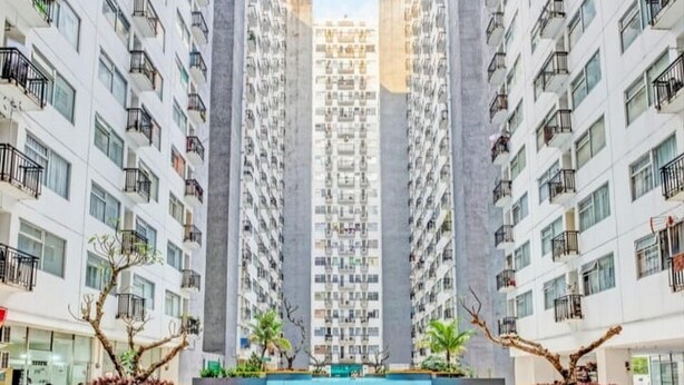A modern high-rise residential building with balconies, a central courtyard with a pool, and surrounding greenery. - Hotel O The Jarrdin Apartment By Putra Homestay Property (Bandung)